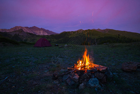 山上黄昏的帐篷和营火燃烧图片