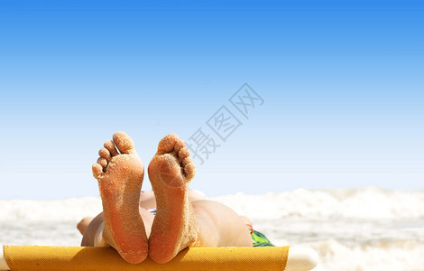 女人的腿在沙滩上放松图片