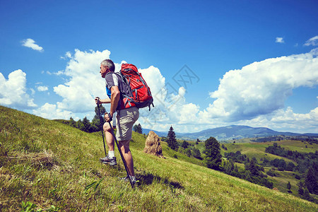 夏天背着包在山上徒步旅行图片