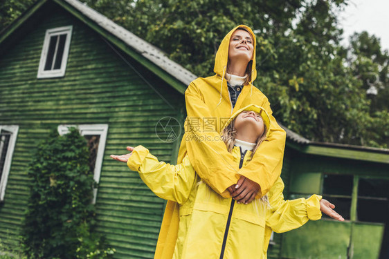 身穿黄雨衣的幸福母亲和女图片