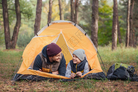 幸福的父亲和儿子躺在帐篷图片