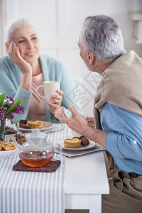 休闲的老年夫妇在家聊天和吃早餐图片