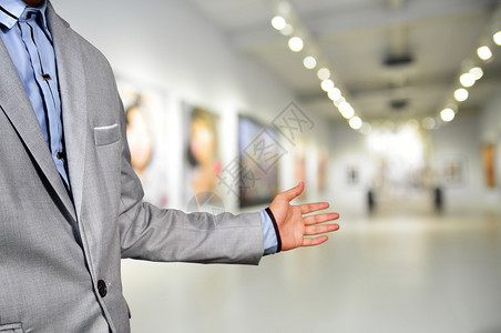 艺术家或摄影师或经理欢迎客人参加他在美术馆或博物馆的形象展图片