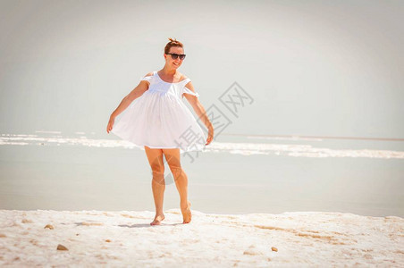 在死海的一个盐岛赤脚跳舞的白衣人年轻有吸引力图片