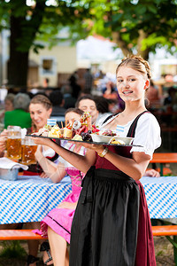 德国巴伐利亚的啤酒花园餐厅提供啤酒和小吃图片