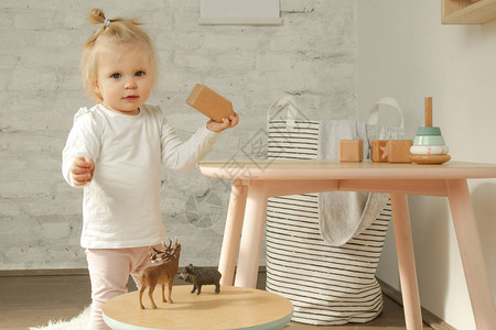 可爱的女婴在育婴室里玩木砖游图片
