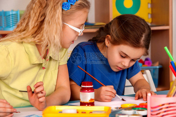 小学生在艺术学校课上画孩子在桌子上用颜料画气球背景上的孩子幼儿园女孩的顶视图绘画教育培养孩图片