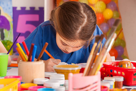 小学生在艺术学校课上画孩子在桌子上用颜料画幼儿园里的男孩和女孩绘画教育培养孩子的创造能力图片