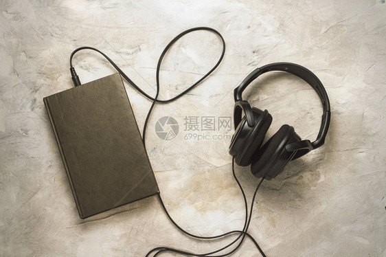 书和耳机在白石背景上连结起来的书和耳机图片