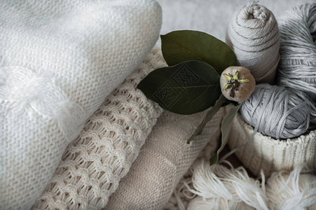 用于编织和针的带有白色和灰色线的编织篮白色毛衣和背景图片