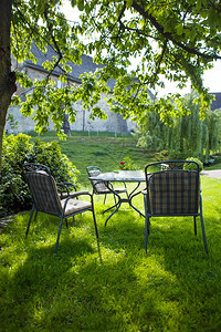 美丽的夏日花园配有白色桌椅图片
