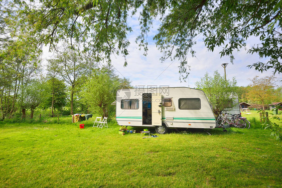 露营地绿色草坪上的白色大篷车拖晴天春天的风景欧洲生活方式旅行生态旅游公路旅行旅程假期娱乐交通图片