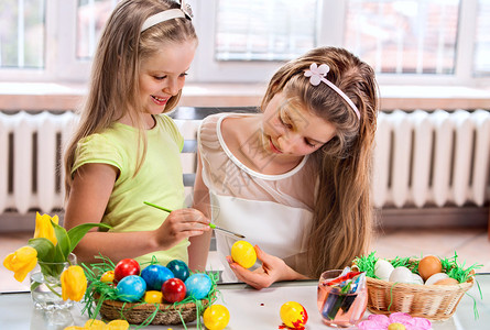 女孩在家里画复活节鸡蛋在图片