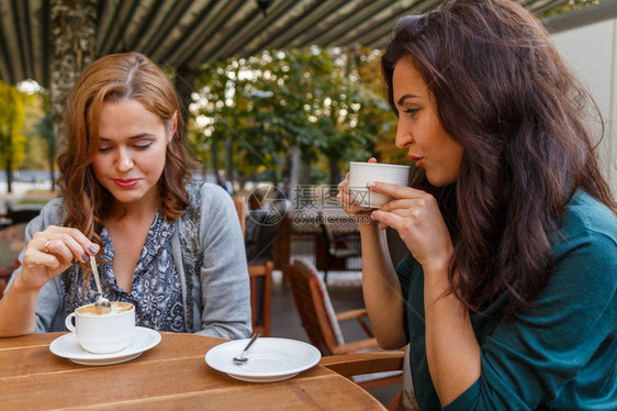 在街上咖啡馆喝咖啡的女孩图片