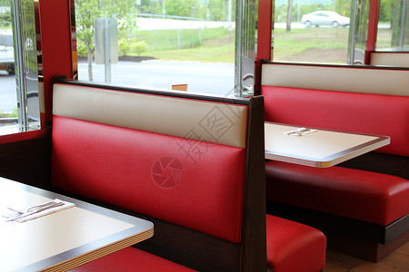 当地餐厅内有多彩红色棕色皮革摊位和木桌图片