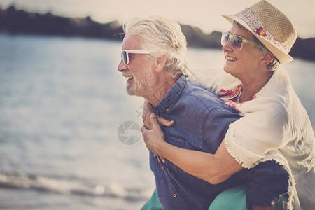快乐的老年夫妇在海滩玩得开心图片