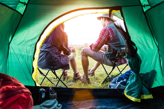 男女露营者在露营帐篷前交谈人和生活方式的概念野餐和旅行的概念夏季主题的自然后视图图片