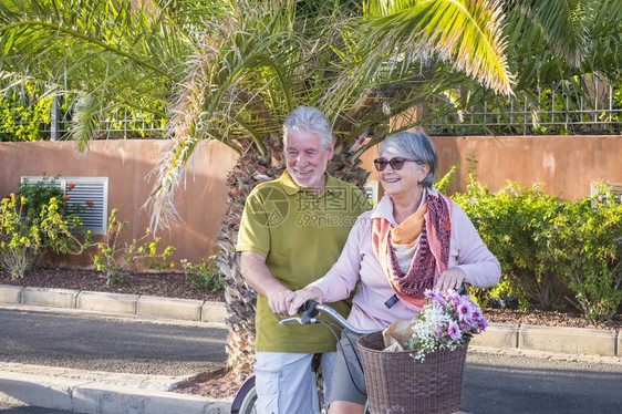 老男人和女人在户外摆着旧自行车合影图片