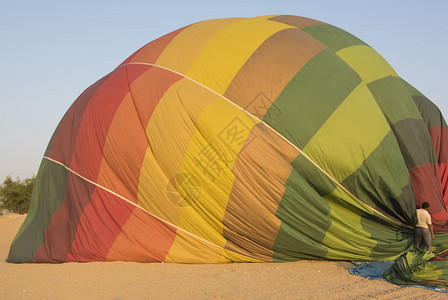 多色热气球在落到沙漠地面后被降压图片