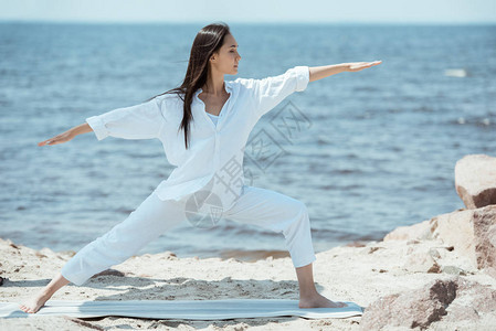 在海面垫子上做瑜伽的青壮年女子二号图片