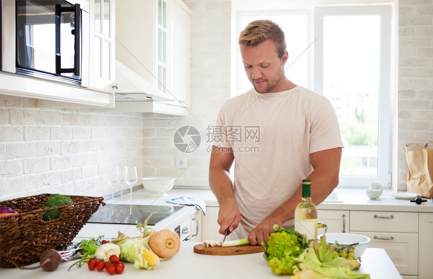 在家做饭的英俊年轻男子在图片