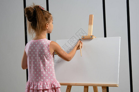 可爱的黑发儿童艺术家在她的头发上打着蝴蝶结图片