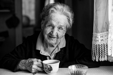 老年妇女喝茶的肖像黑白照片图片