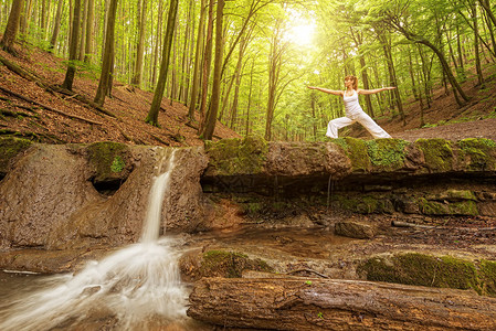 放松女人在瀑布练习瑜伽图片
