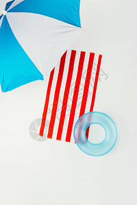 沙滩伞条纹毛巾和充气环的顶部视图背景图片