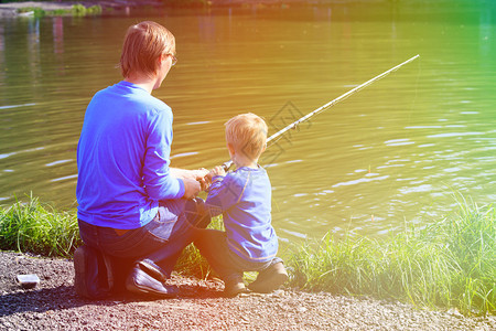 父亲和儿子在湖边钓图片