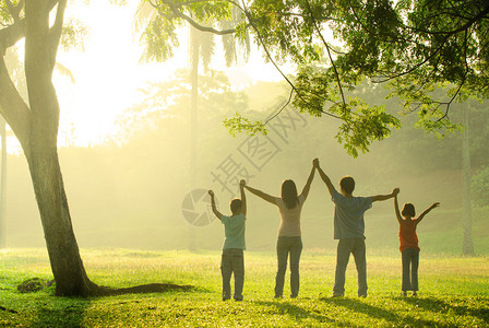 在一个美丽的日出背光下一个亚洲家庭在公图片
