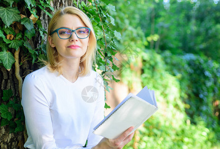 女孩放松与书绿色自然背景文学作为爱好热衷于书的女孩继续阅读畅销书排行榜概念金发碧眼的女人在公园背景图片