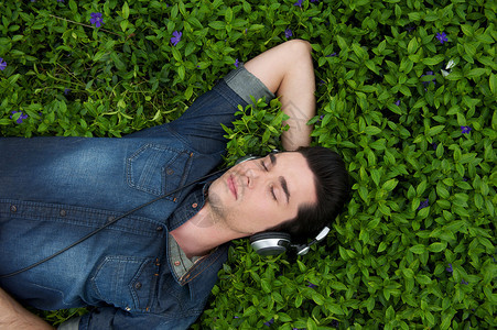 一个年轻人的肖像躺在草地上眼睛闭着图片
