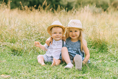 坐在田野里的可爱快乐的金发孩子图片