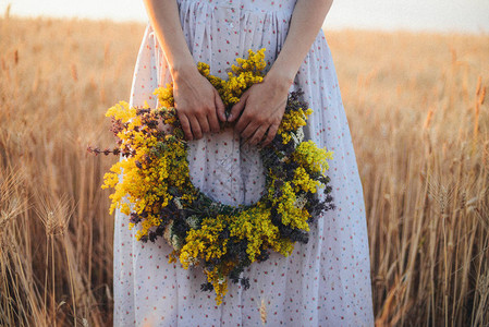 美丽的女孩在阳光明媚的日子在草地上的花环图片素材