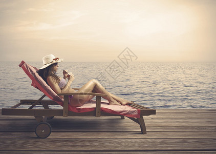 日落时在海滩上放松的女人图片