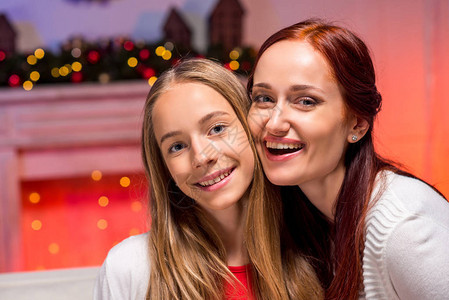 快乐美丽的母亲和女儿拥抱在圣诞节图片