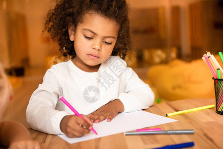 可爱的非洲裔美国孩子在幼儿园用粉色毡笔画图片