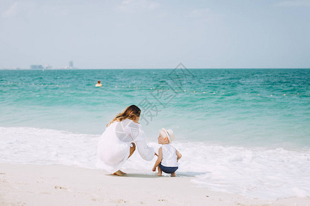 阿联酋迪拜沙滩上的年轻母亲和图片