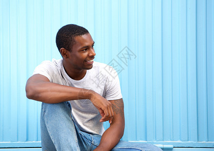 一个微笑的年轻男人的肖像坐在图片