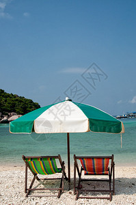 泰国海滩上的两把椅子和雨伞图片