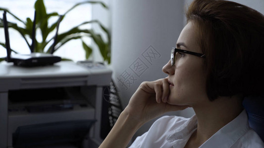 年轻的女工在办公室的椅子上休息戴着眼镜坐在办公室办公桌前电脑前的年轻冷静图片