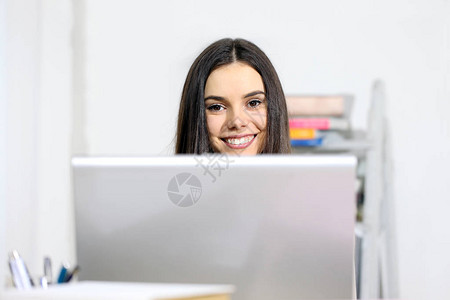 在电脑面前微笑的年轻女子快乐的信息图片