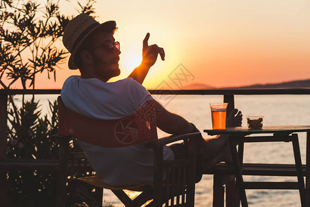 年轻男人在海滩酒吧享受日图片