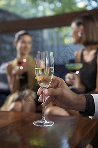 男手握着香槟的杯子在两图片