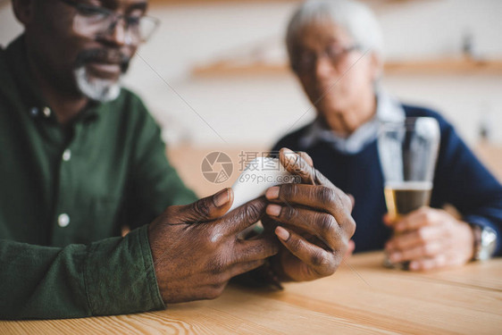 在酒吧与朋友共度时光使用智能手机的非洲图片