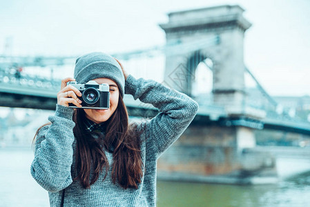 摄影记者在背景上拍摄旧的欧洲之桥并拍图片