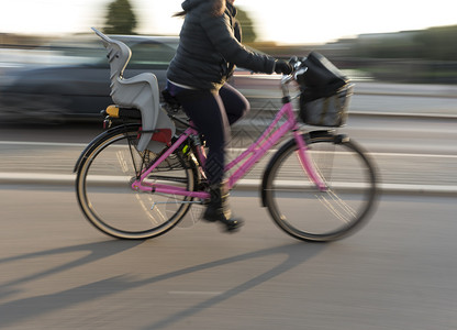 女在粉色自行车上与儿童座椅背景图片