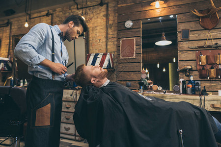 理发店里顾客的男理发师剪头发图片