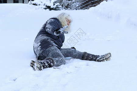 一个女人在冬天的路上滑倒在滑图片